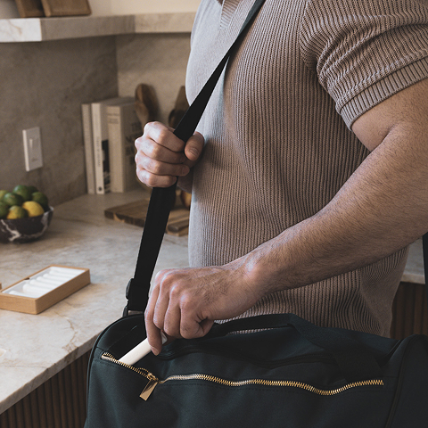 Man putting a capusle of Stack into his bag.